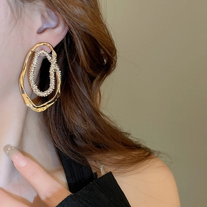 Close-up of gold irregular double hoop earrings with pave rhinestones on model side profile