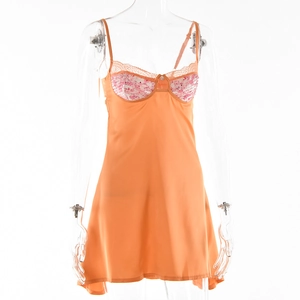 Dettaglio della sottoveste in raso arancione con coppe in pizzo floreale rosa e bordi