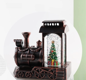Detail of vintage Christmas train snow globe with bronze texture and festive tree inside