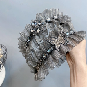 Detailed shot of pleated fabric headbands with rhinestone butterfly and flower patterns