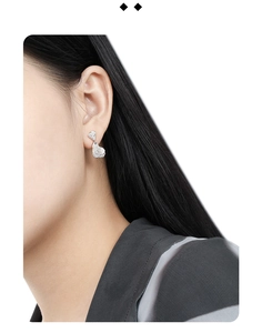 Detail view of irregular silver lava texture earrings worn on a model's ear