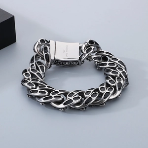 Detail of 316L stainless steel skull cuban chain bracelet with black enamel accents