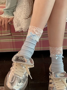 Détail de chaussettes bleues à côtes avec bordure en dentelle et nœud chic