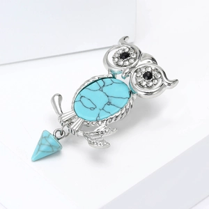 Retro owl brooch with turquoise stones and shimmering rhinestones on white studio geometry