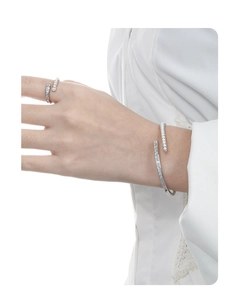 Detail shot of silver open cuff bracelet and ring set with pearls and zircons