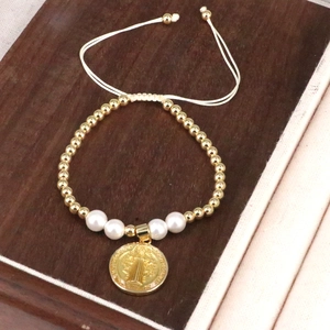 Handmade bohemian braided bracelet with gold beads, pearls and a religious coin pendant
