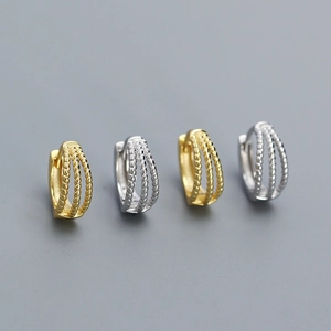 Detail of four multi-layer braided twist hoop earrings in gold and silver finishes