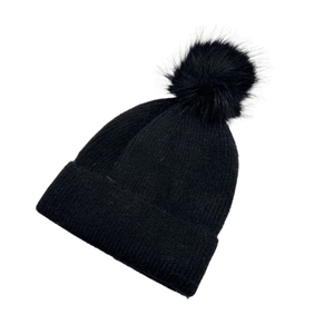 Close-up of black ribbed knit beanie with fluffy faux fur pom-pom and folded cuff
