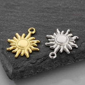 Close-up of gold and silver sun-shaped pendants made of polished titanium steel for DIY