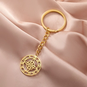 Macro detail of golden stainless steel keychain with cutout lunar witch knot charm