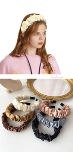 Detail of elegant pleated satin headbands in multiple colors with luxury styling