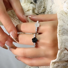 Close-up of adjustable knotted zircon rings with a black flower design and sparkling stones