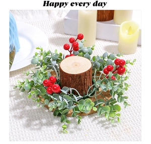 Detail of Christmas candle ring with red berries and green eucalyptus leaves on wood