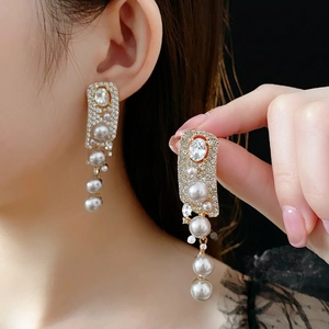 Elegant gold drop earrings with tiered white pearls and crystal tassels for a luxury look