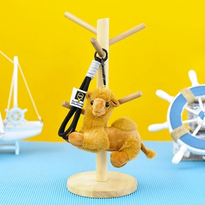 Detailed view of a cute camel plush keychain on a wooden accessory stand