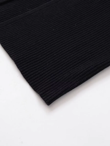 Close-up detail of high-quality black ribbed knit texture on a midi dress fabric