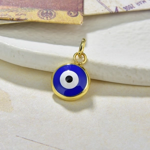 Detailed macro view of an enamel evil eye pendant with a polished gold plating finish