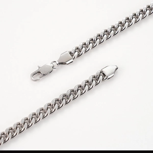 Detail shot of silver Cuban link bracelet featuring a durable lobster clasp closure