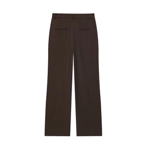 Détail du pantalon marron à taille haute et jambes larges montrant la texture tissée et poches