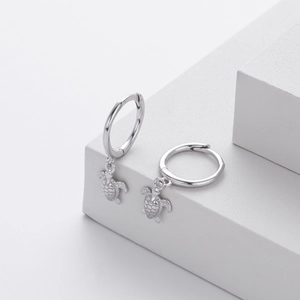 Detailed close-up of polished S925 sterling silver hoop earrings with sea turtle pendants