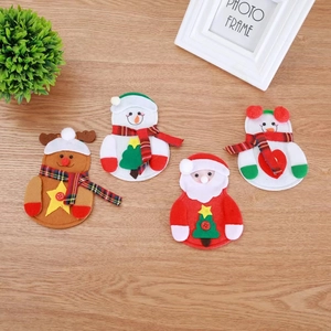 Christmas silverware holders featuring Santa and Reindeer on a rustic wooden table