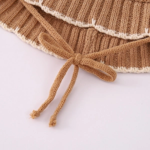 Detail of coffee knit bucket hat featuring white wavy embroidery and soft texture