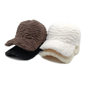 Pile of soft sherpa baseball caps in brown black white and beige plush faux lamb fur