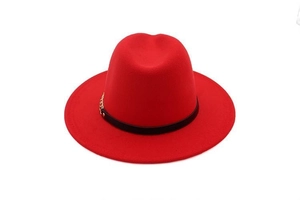 Detail of red wool felt fedora featuring a black leather band and metal chain decoration