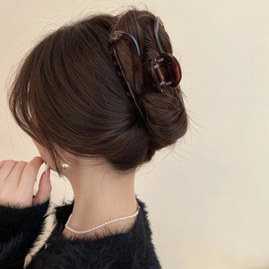 Detail view of a large leopard print tortoiseshell hair claw clip used for a French twist