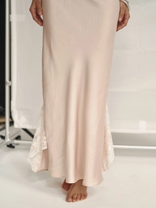 Vue détaillée d'une robe en satin champagne avec dentelle blanche et fente latérale