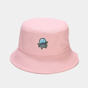 Gros plan de la broderie pieuvre bleue et des coutures sur le chapeau bob rose