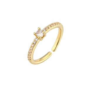 Macro detail of gold adjustable ring with four-prong set cubic zirconia and side pave stones