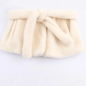 Cream white faux fur coat with waist belt and turnover collar shown in a flat lay view