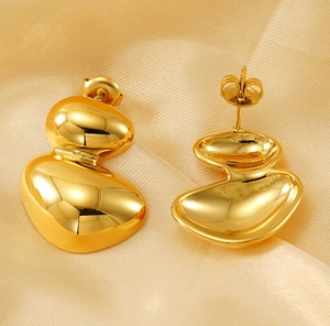 Detailed close-up of gold-plated irregular oval earrings with glossy mirror finish
