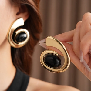 Vintage oval black gemstone gold spiral double-layer earrings on female model