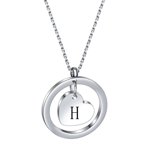 Detailed macro view of an engraved letter H on heart pendant with polished round ring