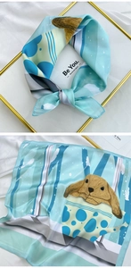Detail of light blue silk scarf featuring hand-drawn rabbit print and elegant gold frame