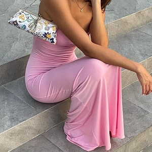 Dettaglio laterale di un abito lungo rosa senza schienale con pochette ricamata bianca