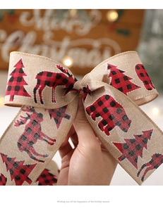 Detailed view of burlap Christmas ribbon bow with plaid reindeer and polar bear patterns