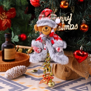 Close-up of teddy bear Christmas ornament with red plaid hat and golden bell