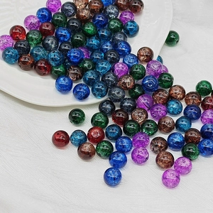 Colorful 10mm cracked glass beads spilled from a white plate for DIY jewelry making