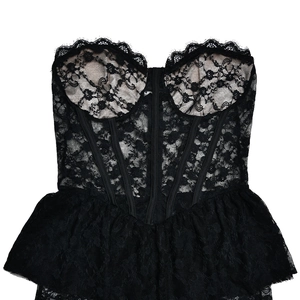 Detailed close-up of the black lace corset bodice and ruffled hemline on the dress