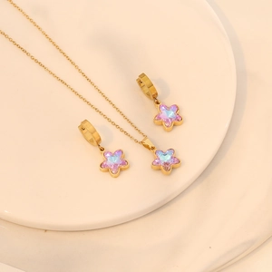 Golden necklace and earrings set with star pendants and pink gradient crystals