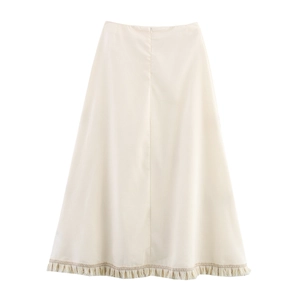 Detail shot of beige A-line skirt with soft fabric texture and decorative fringe hem