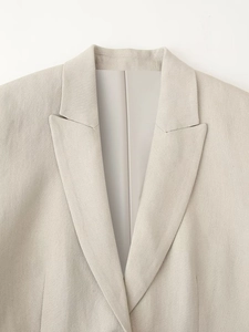 Detail of the notched lapel and textured beige linen fabric on the women's vest