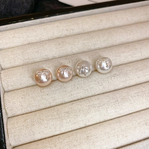 Elegant pearl stud earrings with silver bow design in pink and white set in jewelry box