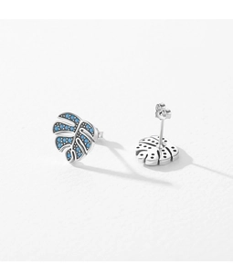 Makroaufnahme von Silber-Ohrsteckern in Monstera-Blattform mit blauen Inlays und Politur