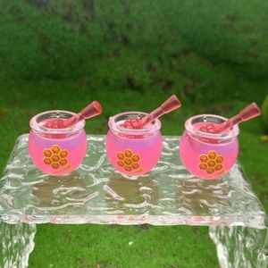Three pink resin honey jar miniatures with dipper sticks on a clear ice-textured stand