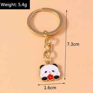 Cute cartoon panda enamel keychain with gold ring and red flower detail on orange background