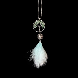 Macro detail of Tree of Life pendant with green stones and light blue feather tassel